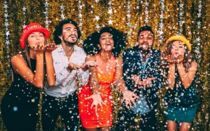 Friends blowing confetti at a new year's party
