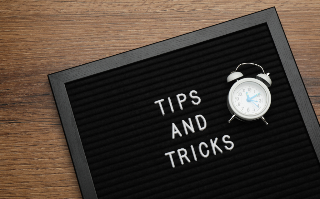 Black Letter Board with Phrase Tips and Tricks on Wooden Table
